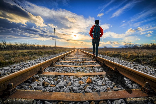 Backpacker walking along train line